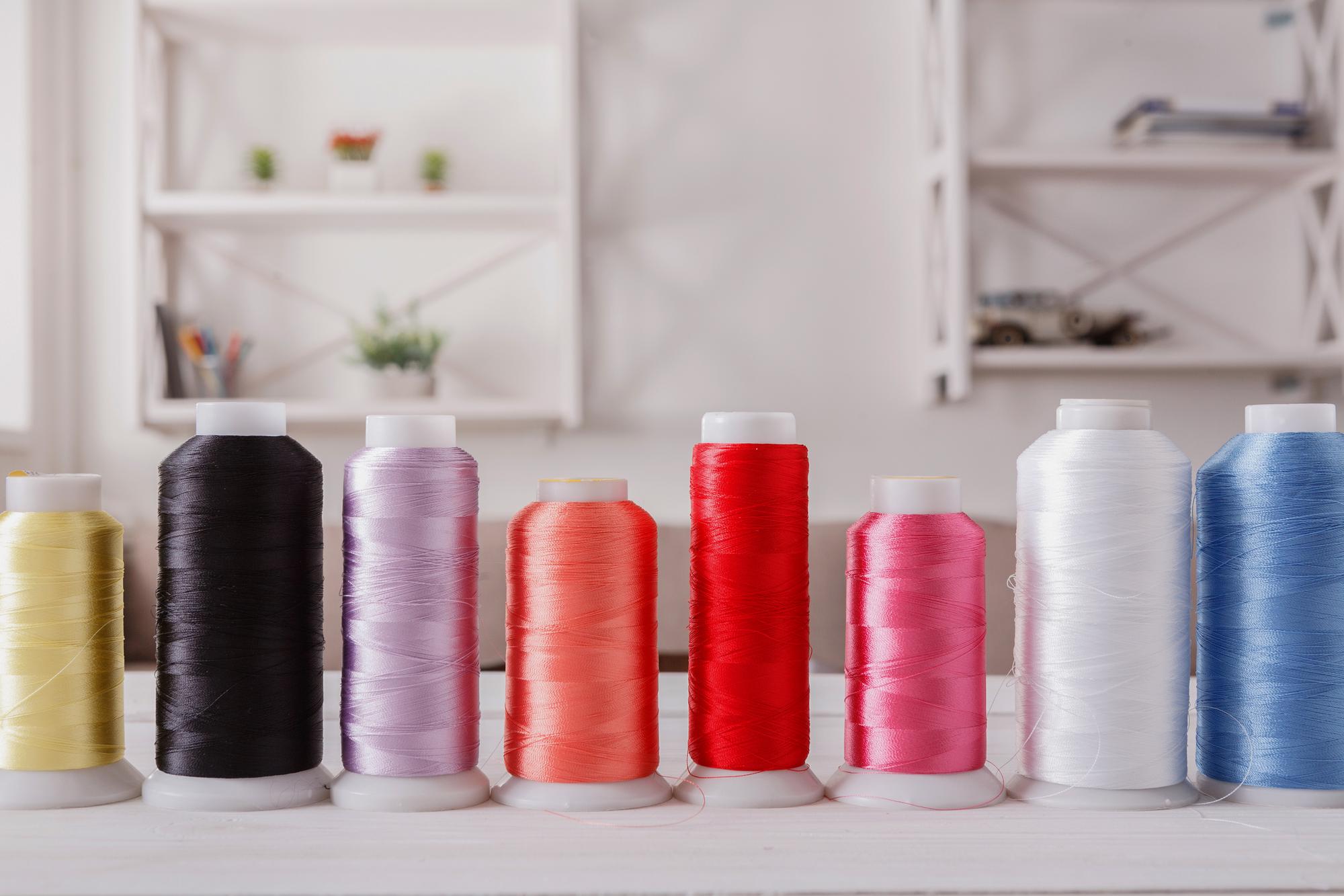 atelier workspace with embroidery frames and thread spools